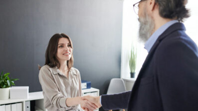 man and woman shaking hands in interview