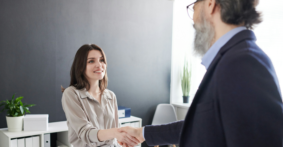 man and woman shaking hands in interview