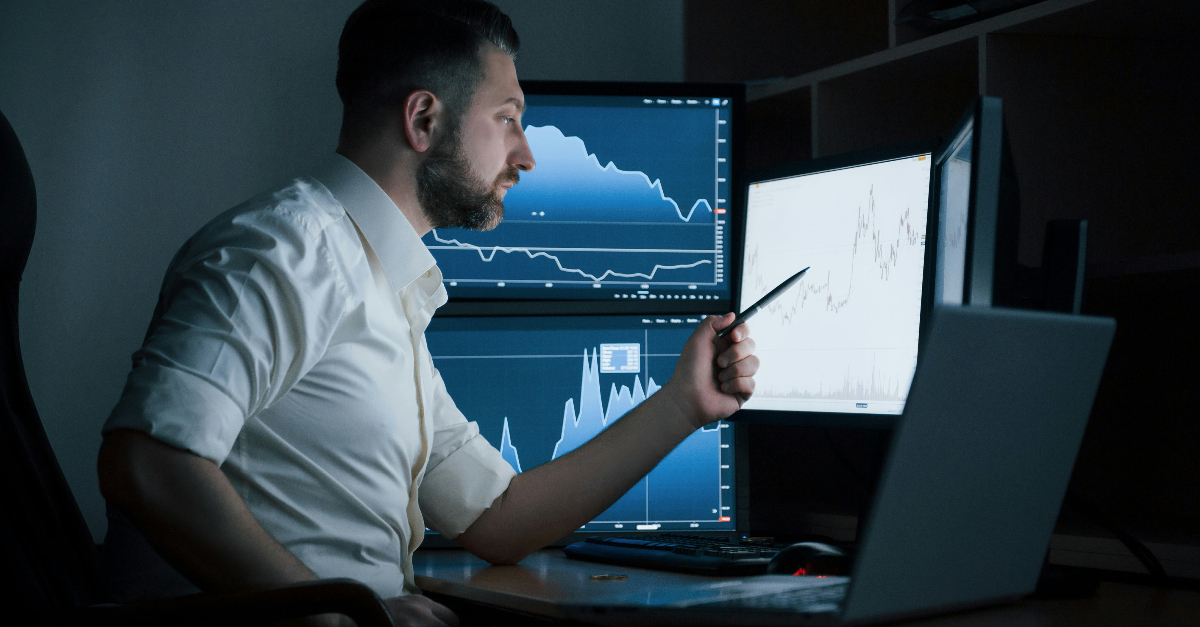 man analysing data on computer screens